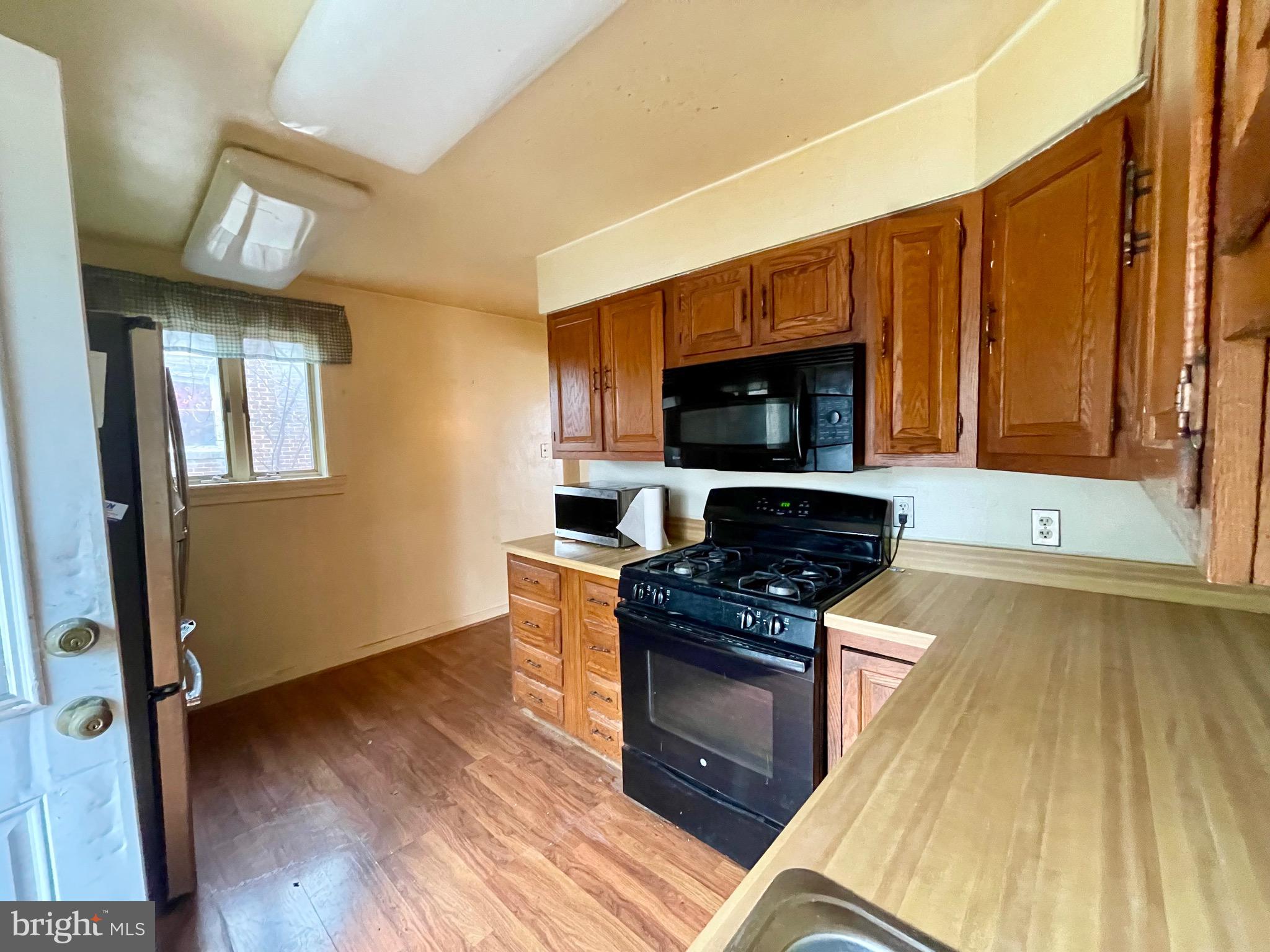 12420 Feldon Street Silver Spring, MD 20906 - Photo 10 of 33 a kitchen with granite countertop wooden floors appliances and cabinets