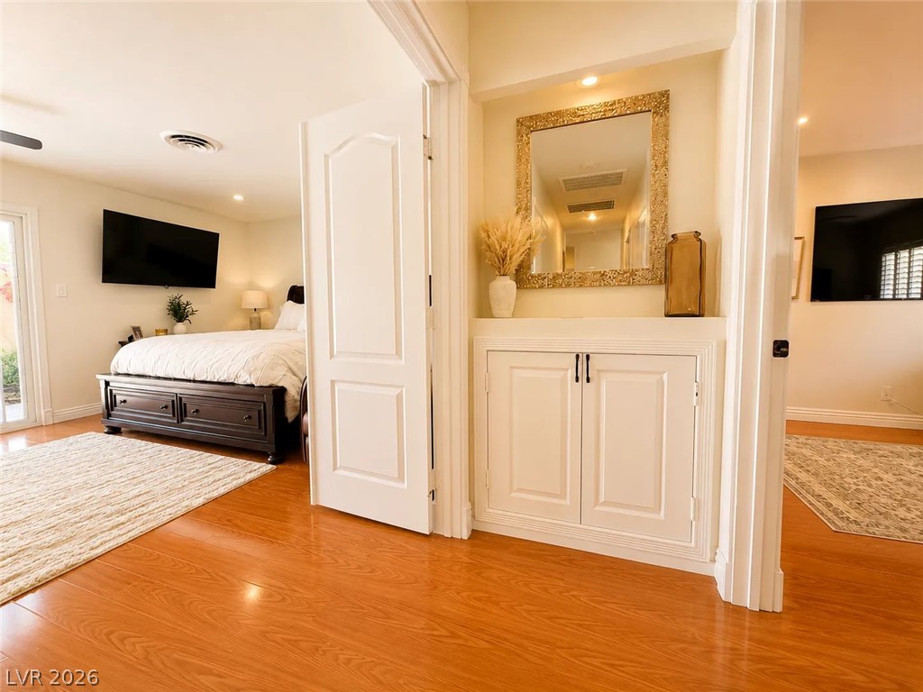 3010 East Viking Road Las Vegas, NV 89121 - Photo 13 of 48 Natural light illuminates rich hardwood flooring leading into a comfortable bedroom space.