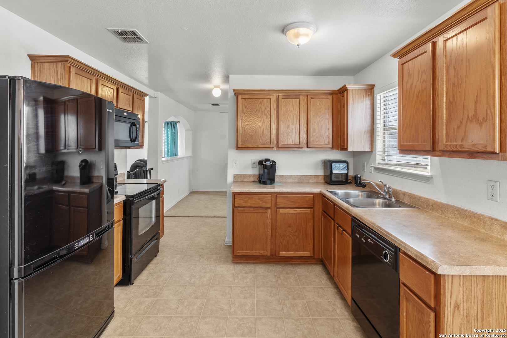 3917 Whisper Ridge Schertz, TX 78108 - Photo 11 of 27 a kitchen with stainless steel appliances granite countertop a sink stove refrigerator and cabinets