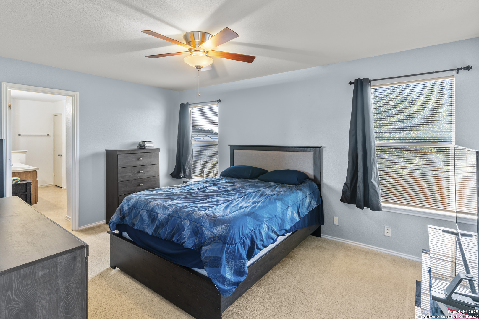 3917 Whisper Ridge Schertz, TX 78108 - Photo 16 of 27 a bedroom with a bed and a chandelier