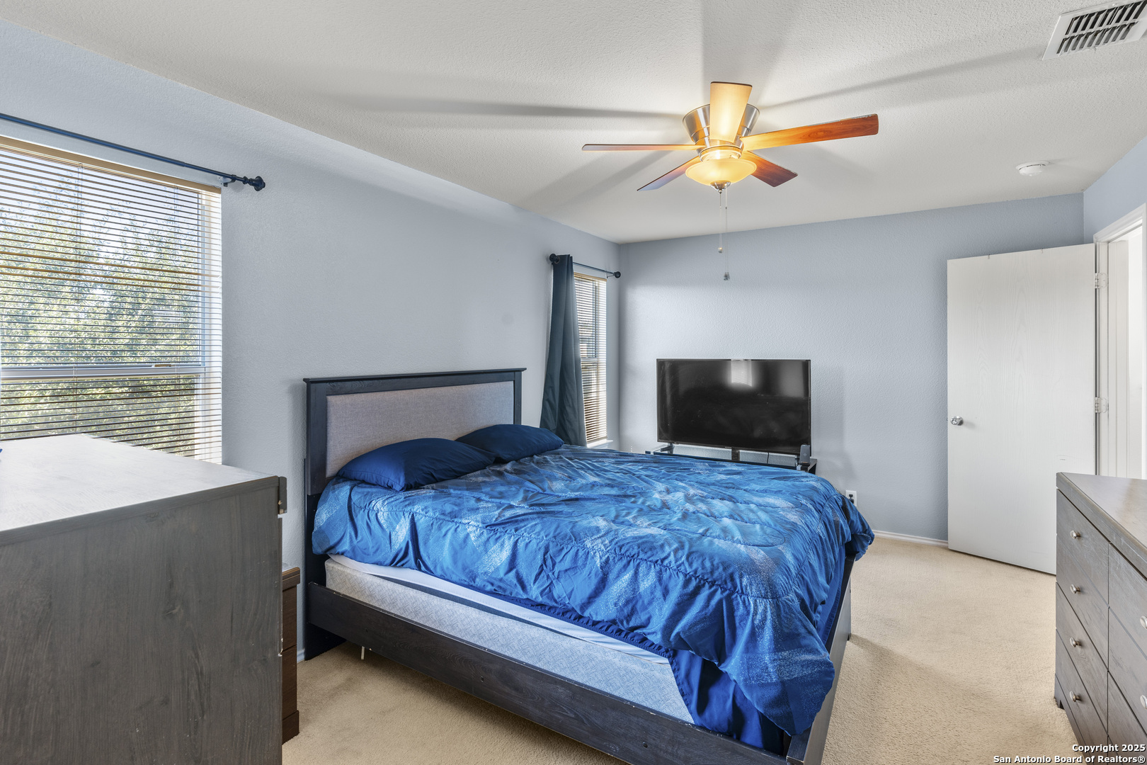 3917 Whisper Ridge Schertz, TX 78108 - Photo 17 of 27 a bedroom with a bed and a flat screen tv