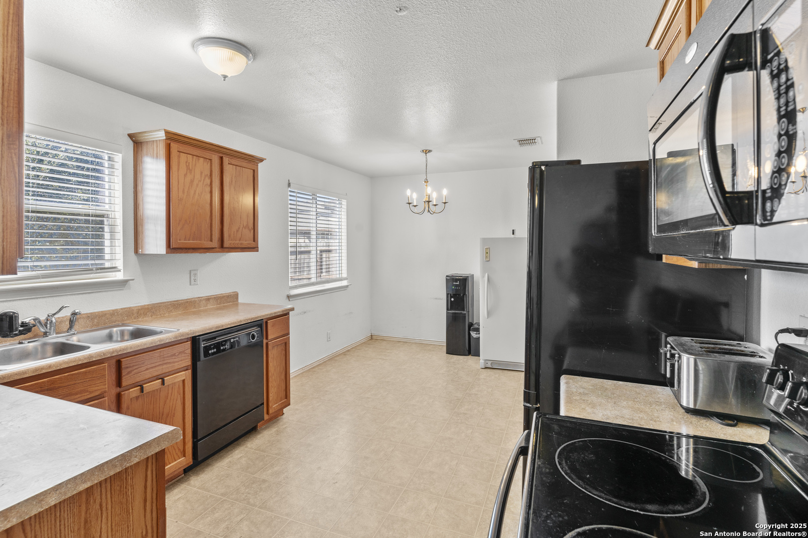 3917 Whisper Ridge Schertz, TX 78108 - Photo 8 of 27 a kitchen with stainless steel appliances a sink stove and refrigerator