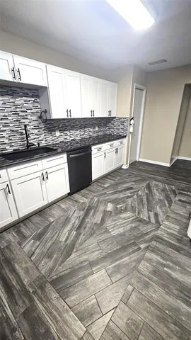 a kitchen with granite countertop white cabinets and white appliances