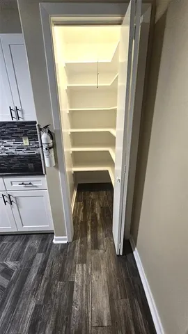 a large kitchen with granite countertop a sink and cabinets