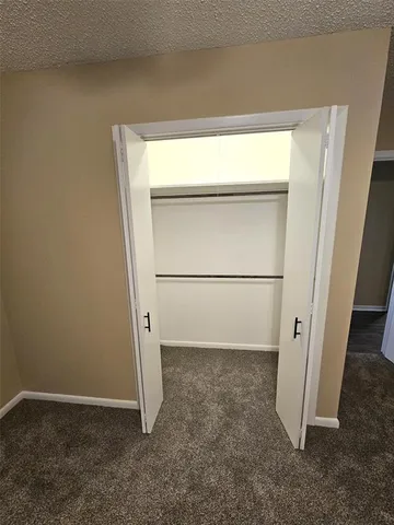 an empty room with a ceiling fan and bathroom