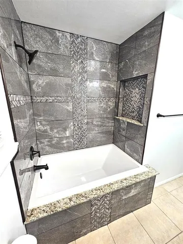 a bathroom with a granite countertop sink a mirror and shower