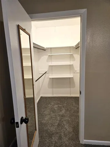 an empty room with a window and a ceiling fan