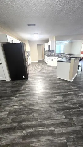 a view of a kitchen with kitchen island white cabinets and stainless steel appliances