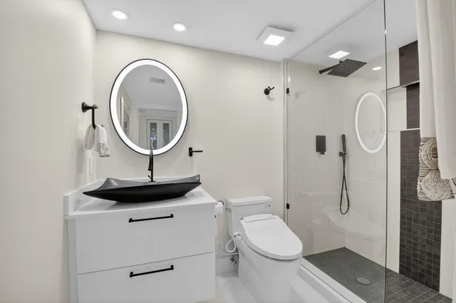 a view of a patio with couches and table and chairs next to an umbrella