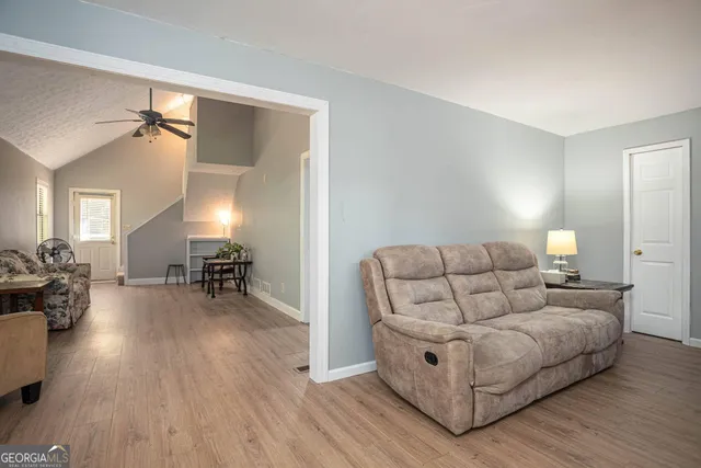 a living room with furniture and a wooden floor