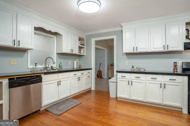 a kitchen with granite countertop white cabinets and white appliances