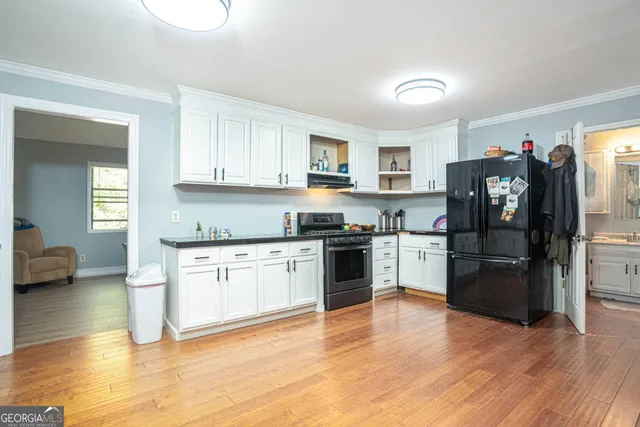 a kitchen with granite countertop a refrigerator and a stove top oven