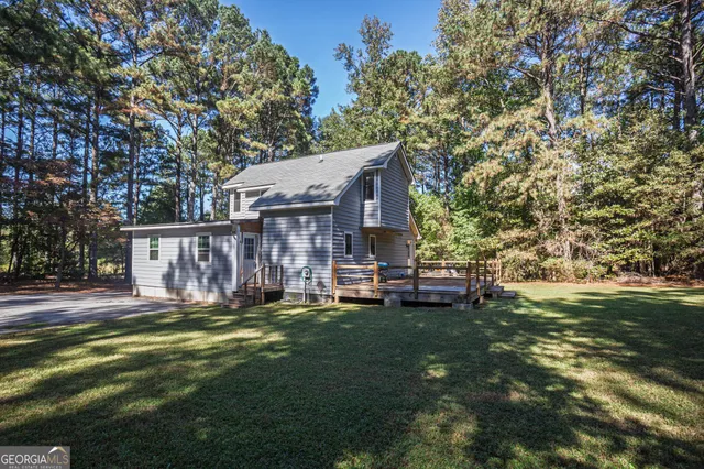 a view of a house with a yard and sitting area
