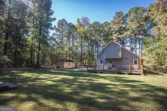 a view of a house with a big yard and large trees