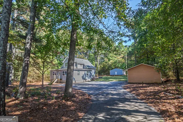 a view of a wooden house with large trees