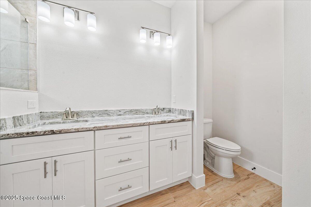 1401 Wilder Road Palm Bay, FL 32909 - Photo 14 of 21 a bathroom with a granite countertop sink a toilet and a mirror