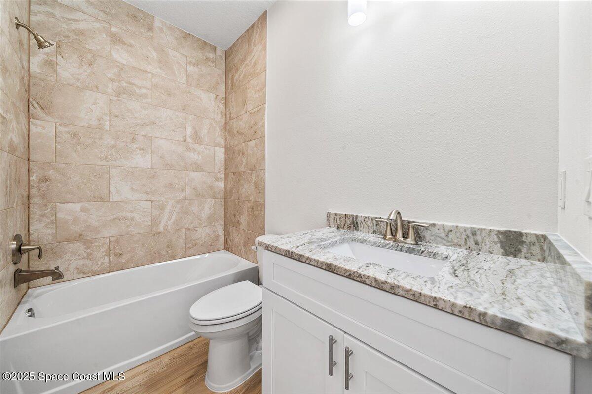 1401 Wilder Road Palm Bay, FL 32909 - Photo 18 of 21 a bathroom with a granite countertop bathtub sink vanity mirror and toilet