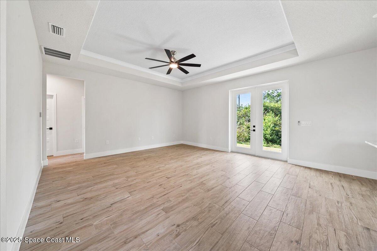 1401 Wilder Road Palm Bay, FL 32909 - Photo 6 of 21 an empty room with wooden floor ceiling fan and windows