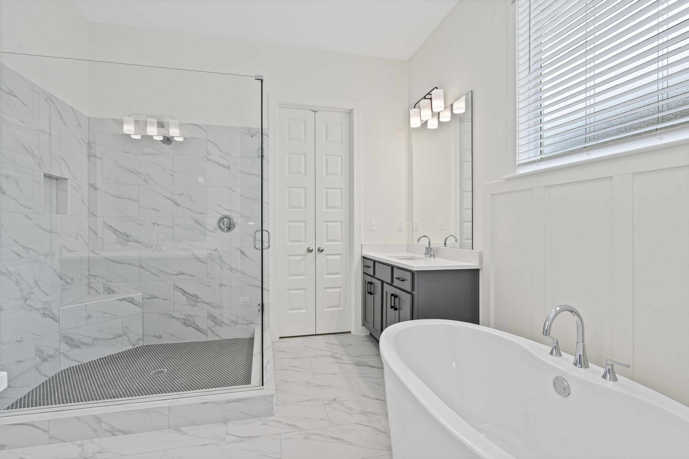5702 Gerber Road Arlington, TN 38002 - Photo 12 of 27 Spacious bathroom featuring a frameless glass shower with marble-look tile, a built-in shower bench, and a dual vanity with a quartz countertop