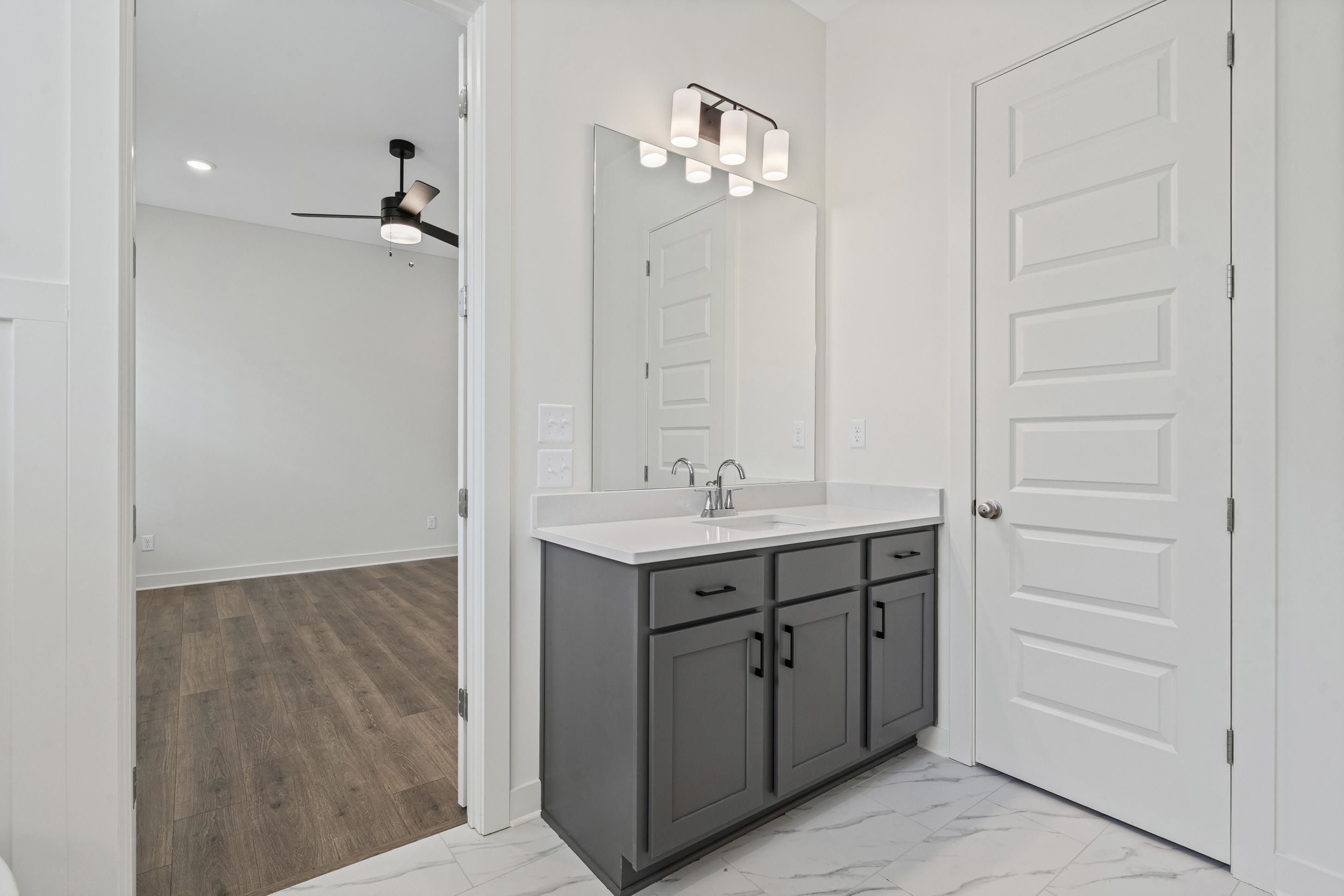 5702 Gerber Road Arlington, TN 38002 - Photo 13 of 27 Vanity with gray cabinetry, white countertop, and chrome faucet