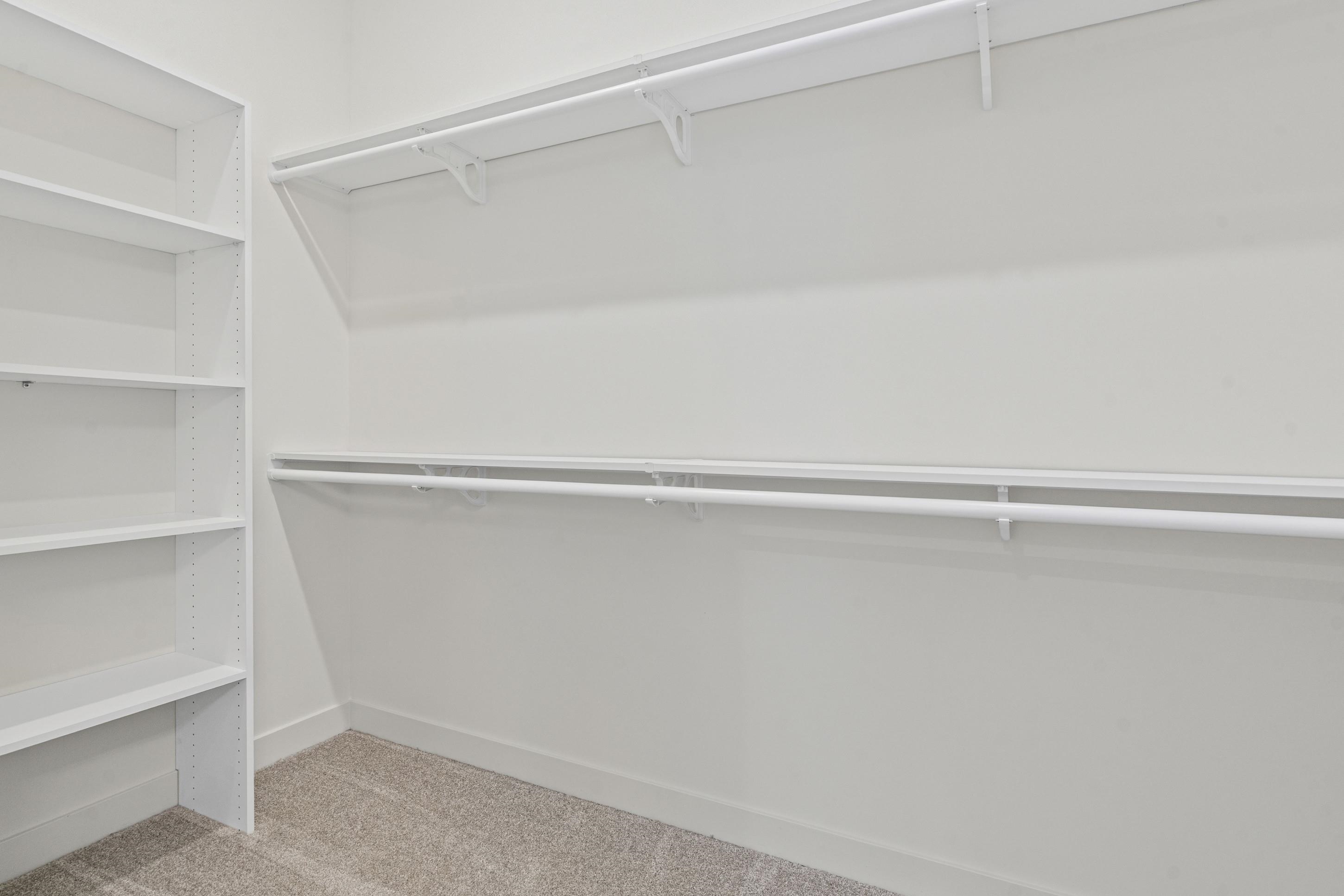 5702 Gerber Road Arlington, TN 38002 - Photo 14 of 27 Walk-in closet featuring built-in shelving, two hanging rods, a single top shelf, white painted walls, and light-colored carpet flooring