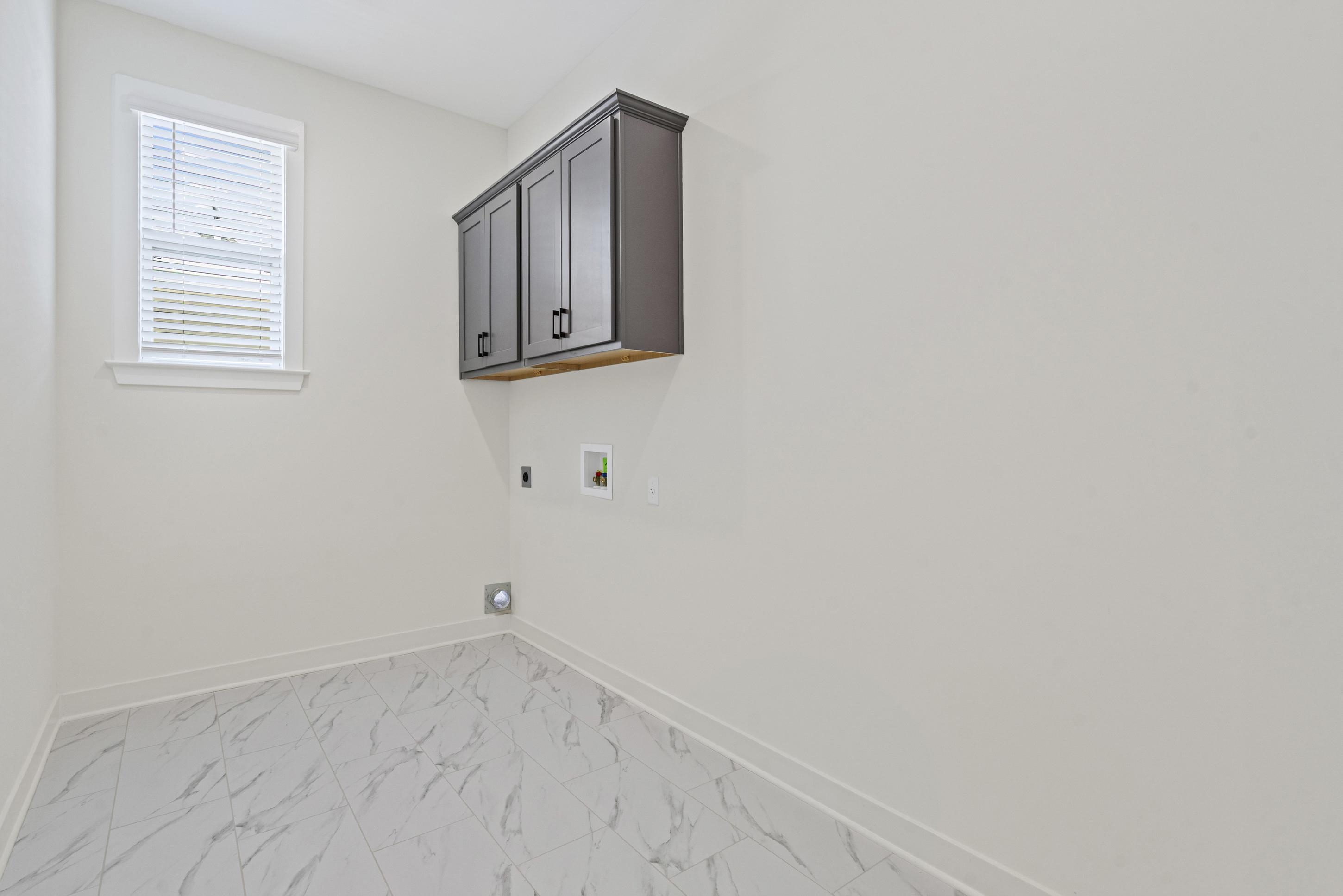 5702 Gerber Road Arlington, TN 38002 - Photo 20 of 27 Laundry area featuring ceramic tile flooring, a window with blinds, and dark gray upper cabinetry with black hardware