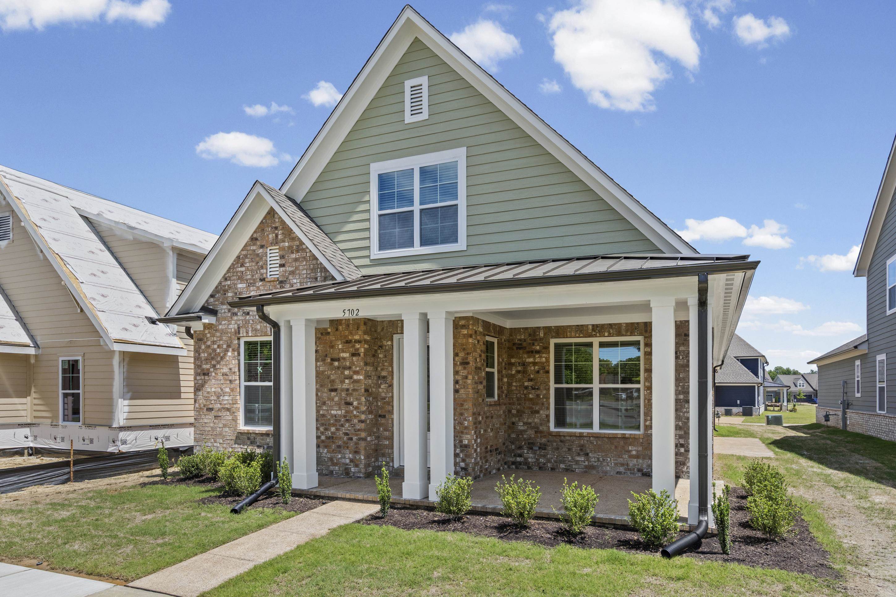 5702 Gerber Road Arlington, TN 38002 - Photo 2 of 27 Two-story residence featuring a covered front porch with white columns, a brick facade, and light green horizontal siding on the upper level