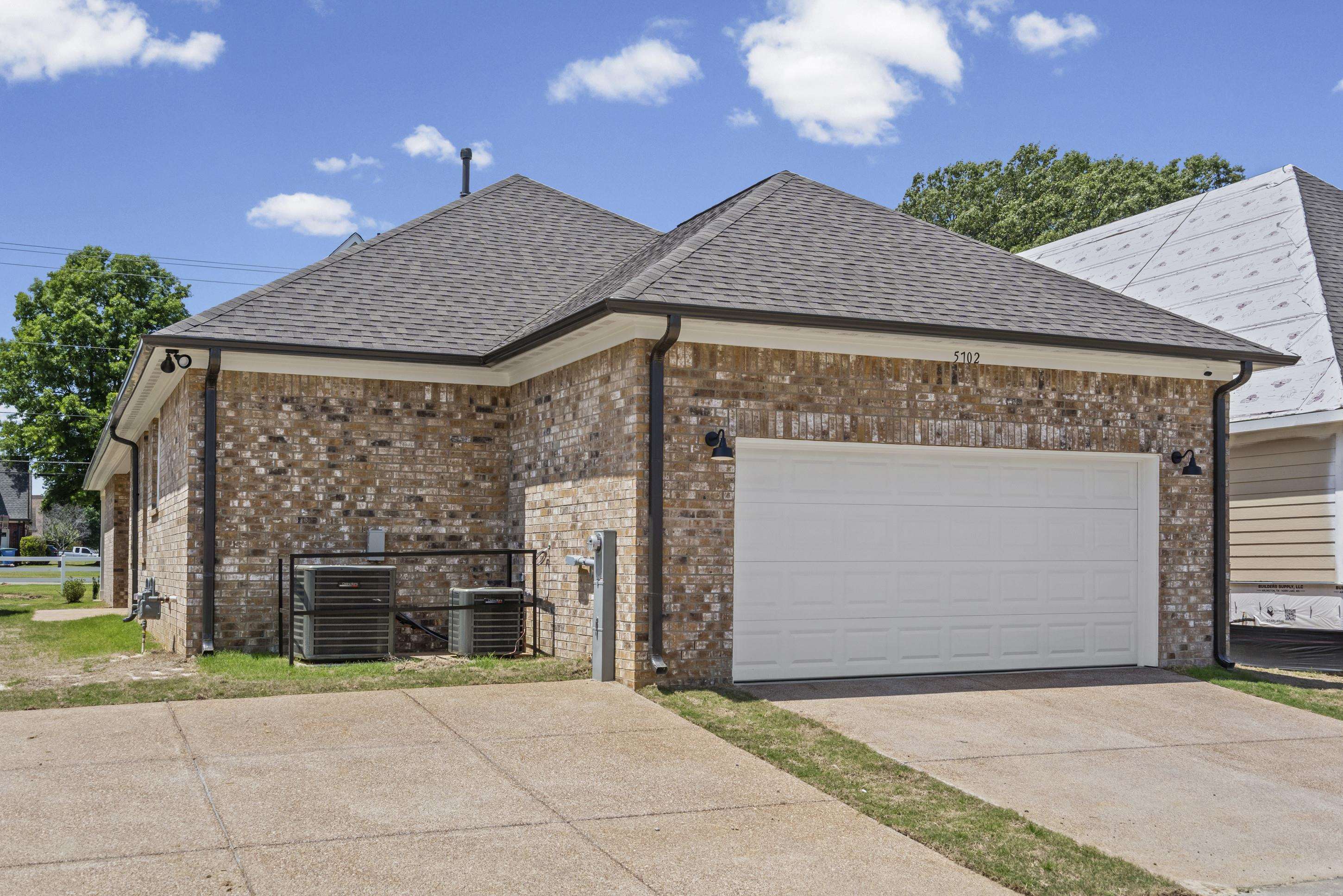5702 Gerber Road Arlington, TN 38002 - Photo 3 of 27 Brick exterior with a white garage door, dark shingle roof, and concrete driveway