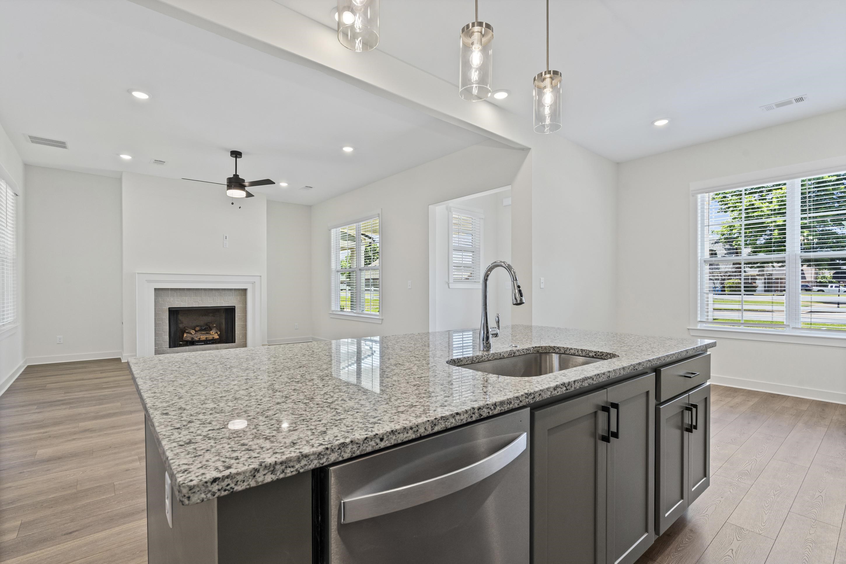 5702 Gerber Road Arlington, TN 38002 - Photo 9 of 27 Kitchen island featuring a stainless steel undermount sink, gooseneck faucet, and integrated dishwasher