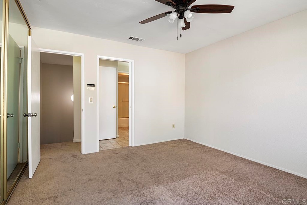 10281 Alphonse Street Santee, CA 92071 - Photo 18 of 26 an empty room with a ceiling fan and carpet