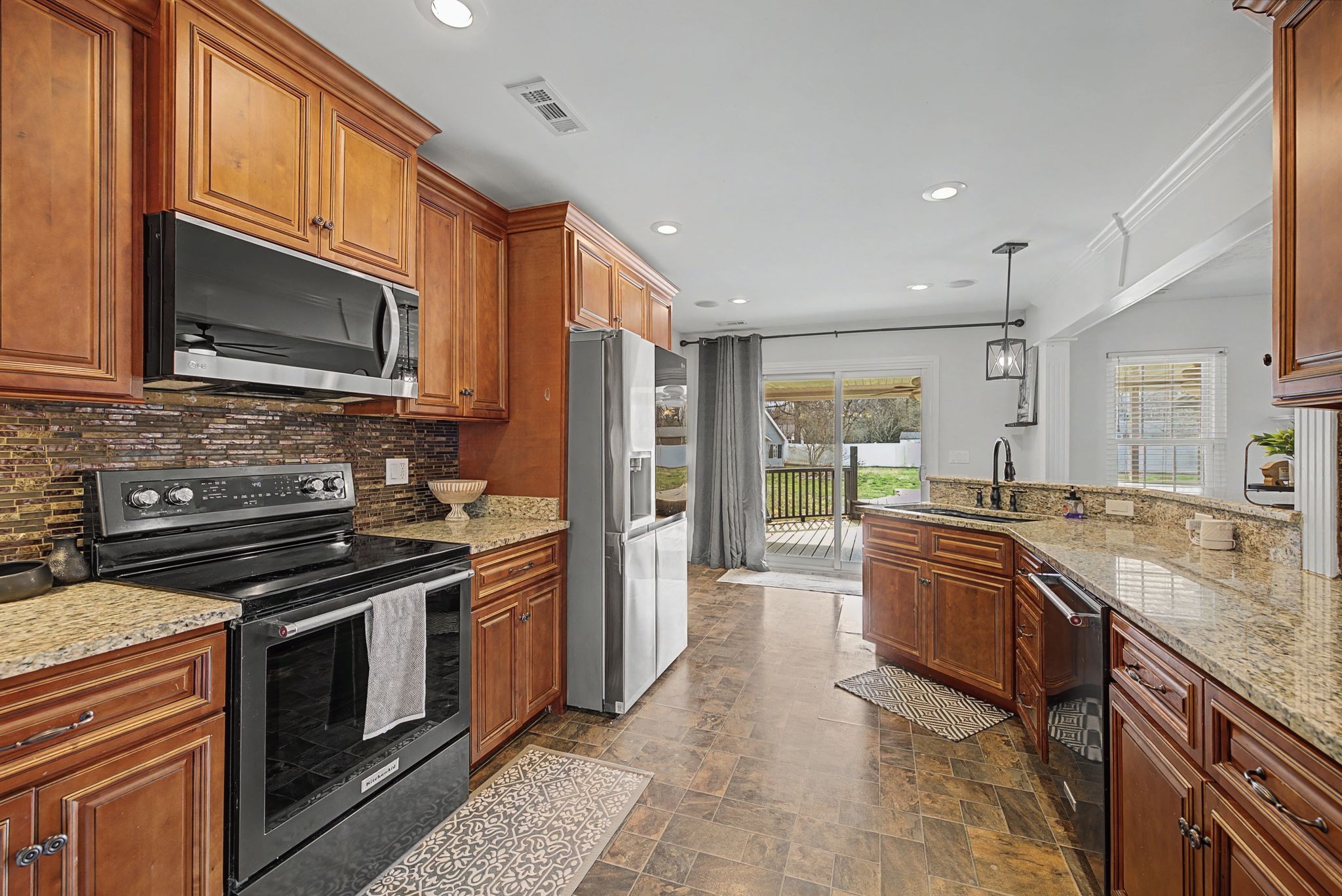1123 Bramble Trail Murfreesboro, TN 37129 - Photo 15 of 41 a kitchen with stainless steel appliances granite countertop a stove top oven a sink dishwasher a refrigerator and a microwave