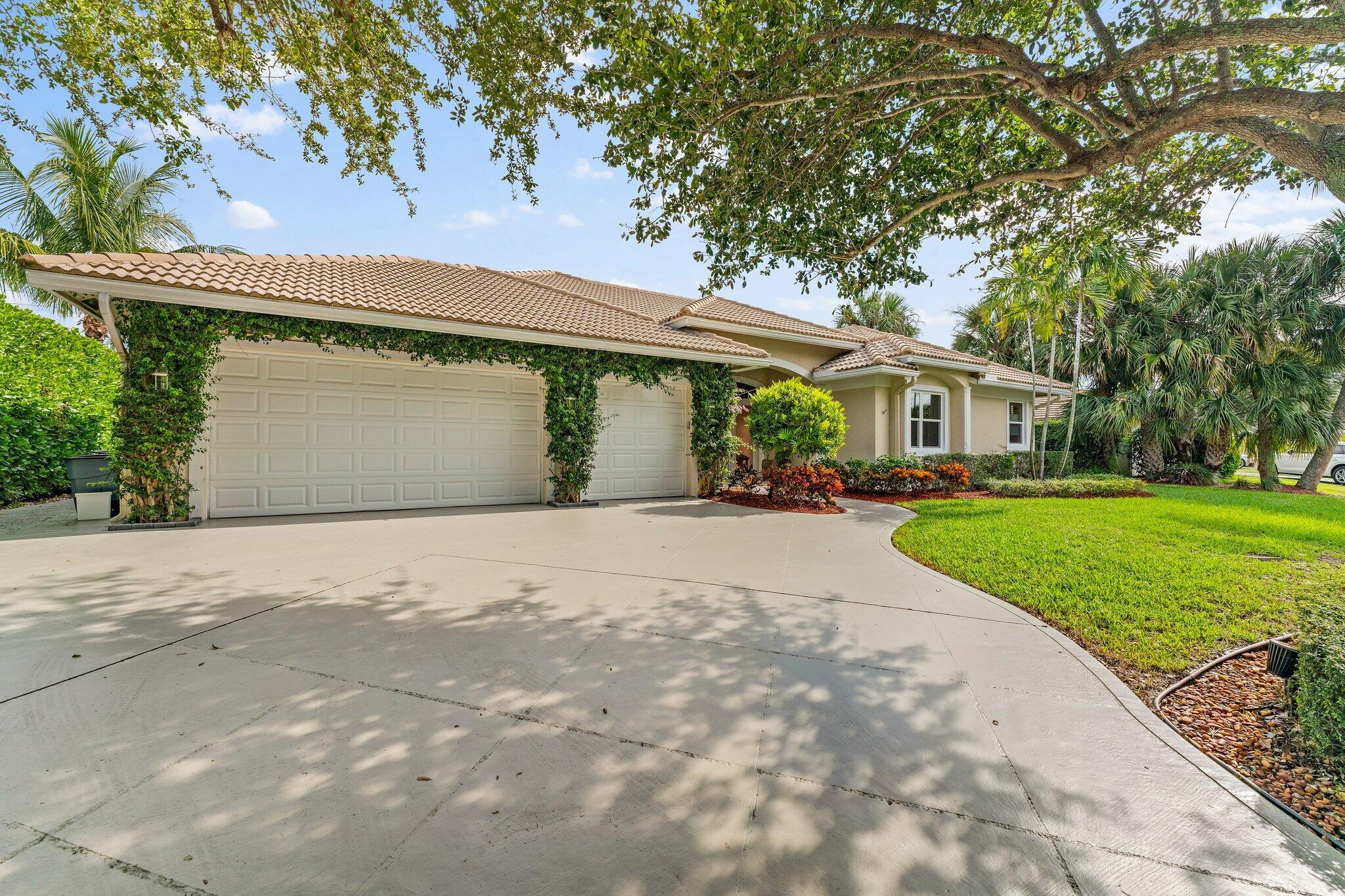248 River Drive Tequesta, FL 33469 - Photo 44 of 65 a front view of a house with a yard and potted plants