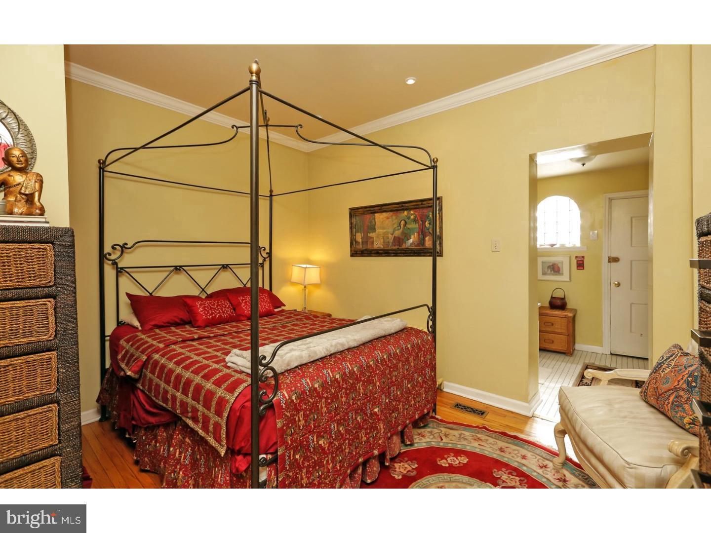 2306 Spruce Street, Unit 100 Philadelphia, PA 19103 - Photo 11 of 19 a bedroom with a bed and a mirror