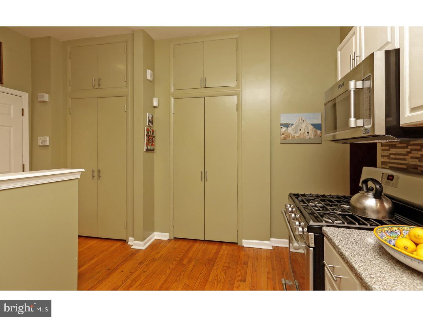2306 Spruce Street, Unit 100 Philadelphia, PA 19103 - Photo 16 of 19 a kitchen with stainless steel appliances granite countertop a refrigerator a stove and a sink with wooden floor