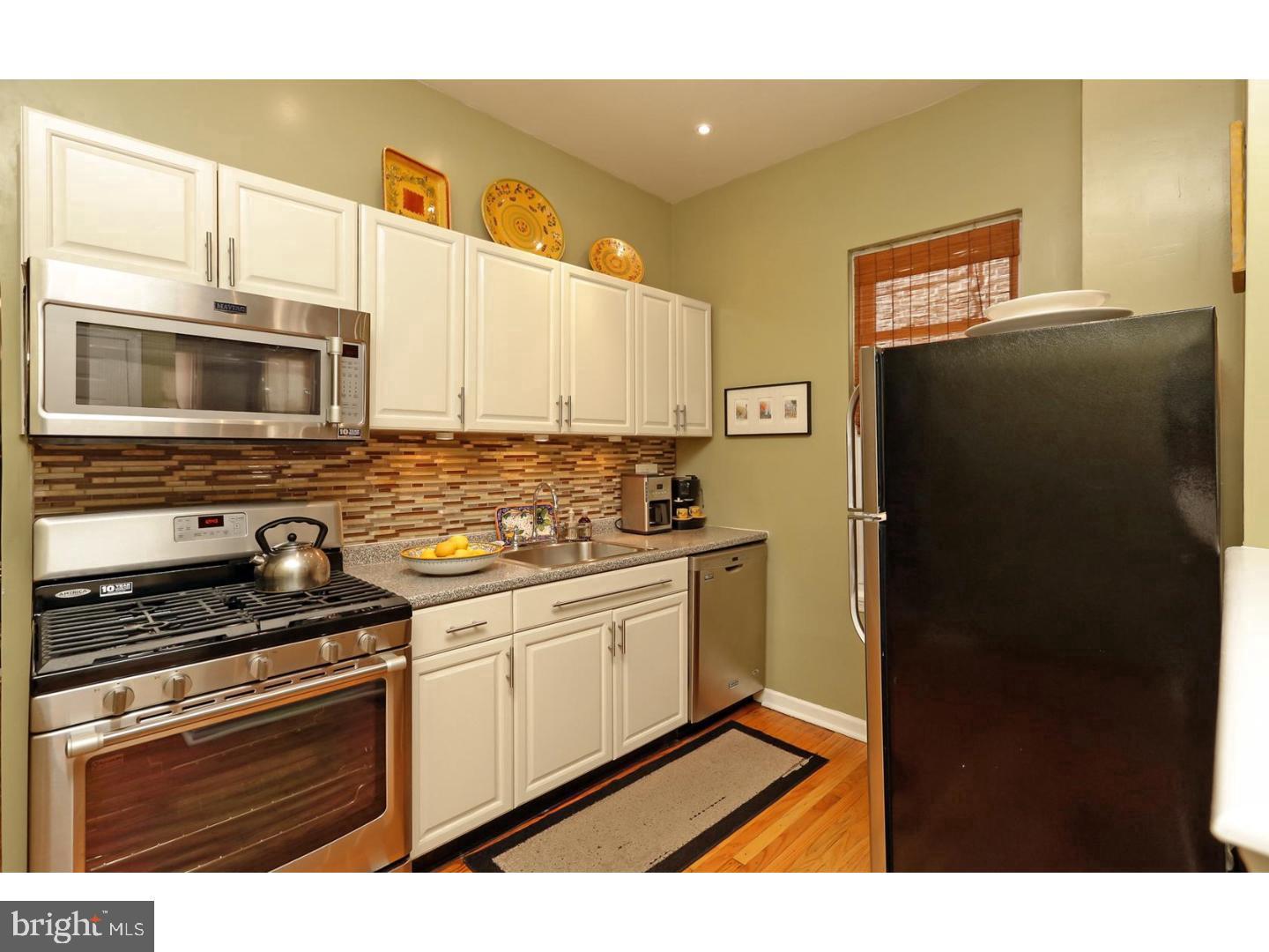2306 Spruce Street, Unit 100 Philadelphia, PA 19103 - Photo 19 of 19 a kitchen with stainless steel appliances a stove a microwave and a refrigerator