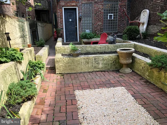 a view of backyard with outdoor seating and plants
