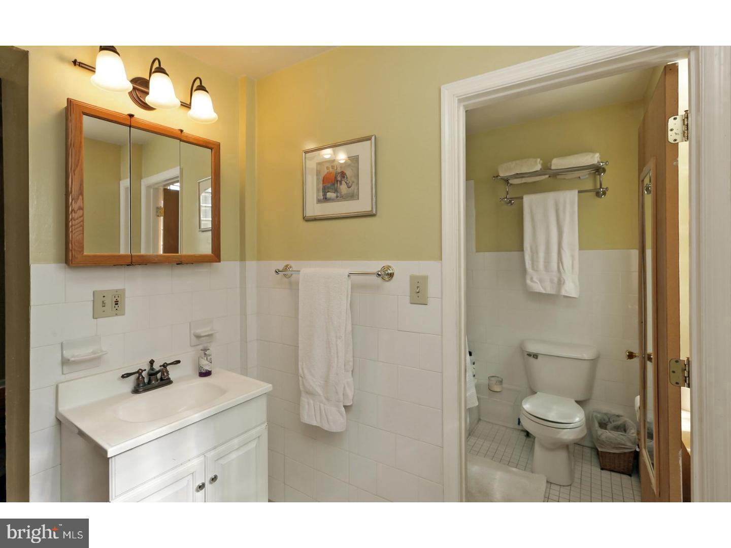 2306 Spruce Street, Unit 100 Philadelphia, PA 19103 - Photo 9 of 19 a bathroom with a sink a toilet and mirror