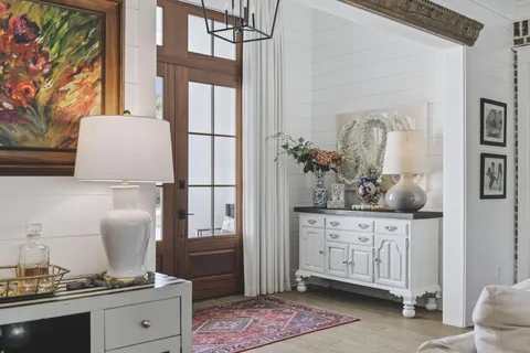 a hallway with a refrigerator and cabinets