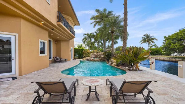 a view of a house with swimming pool and sitting area