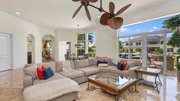 a living room with furniture a chandelier and a large window