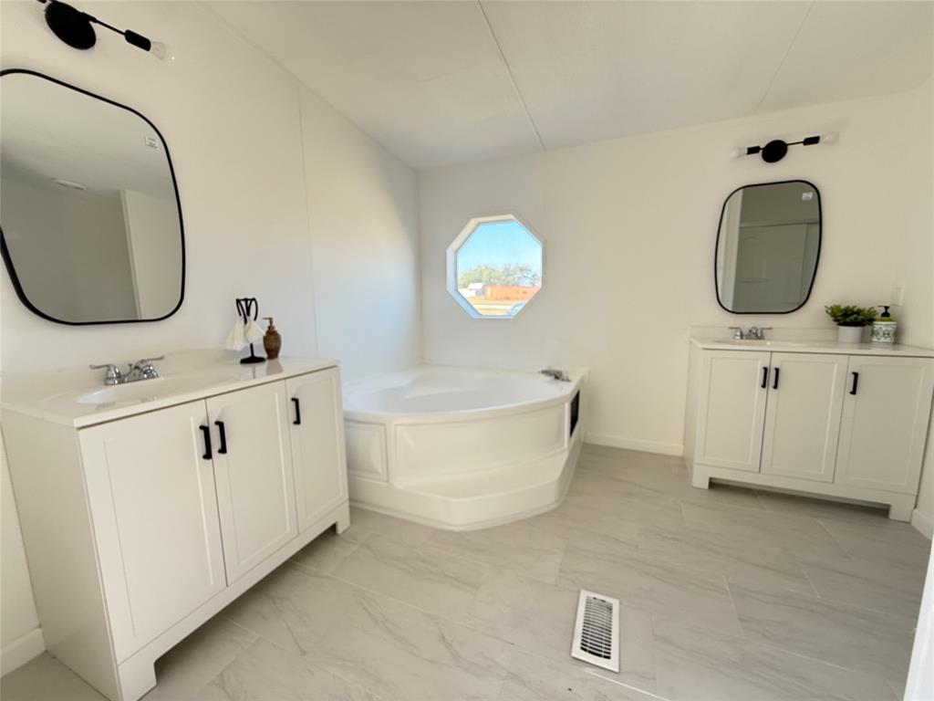 835 Private Road 4732 Rhome, TX 76078 - Photo 17 of 30 a bathroom with a sink a mirror a vanity and a mirror