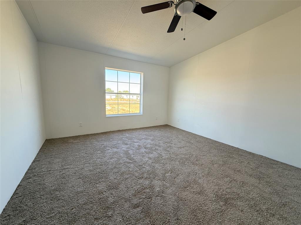 835 Private Road 4732 Rhome, TX 76078 - Photo 21 of 30 an empty room with a window and a ceiling fan