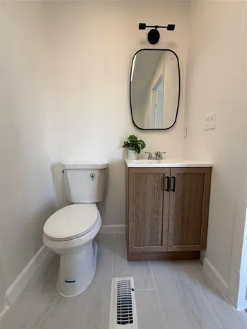 a bathroom with a toilet and a mirror