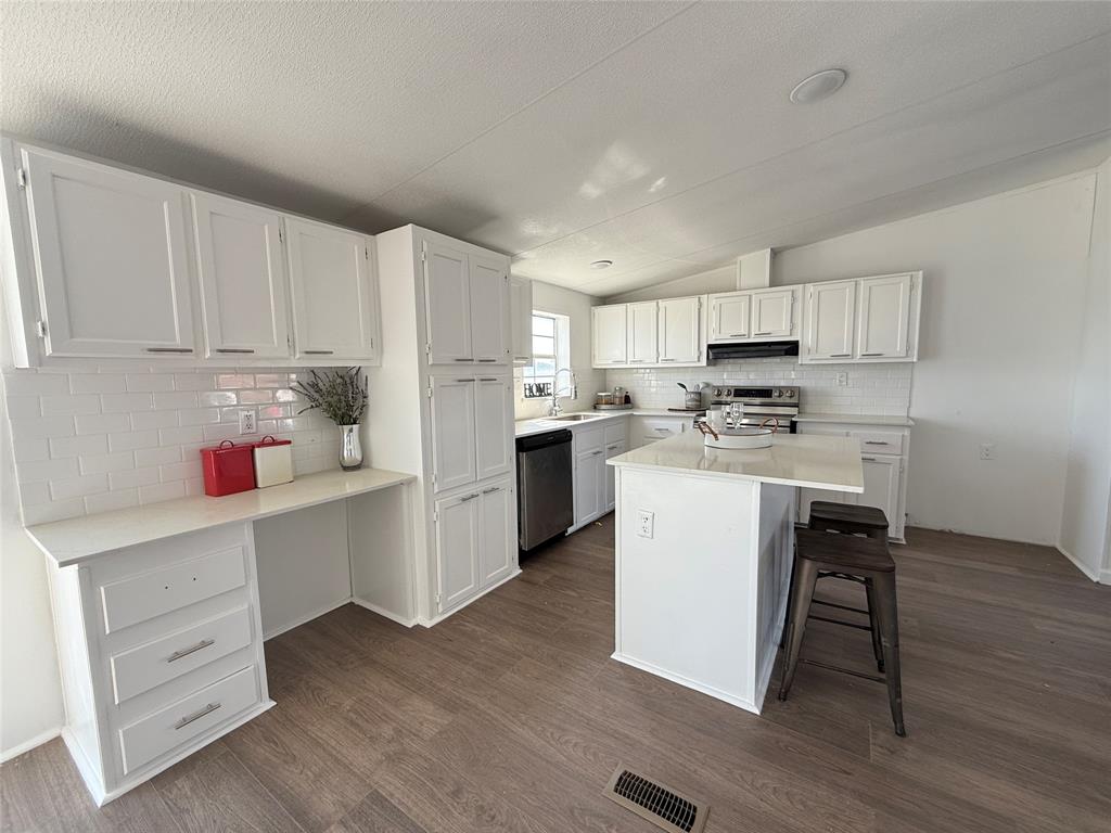 835 Private Road 4732 Rhome, TX 76078 - Photo 4 of 30 a kitchen with a refrigerator a stove top oven and white cabinets