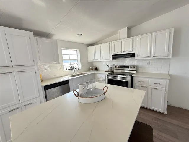 a kitchen with a white stove top oven and white cabinets