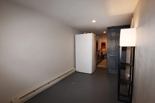 a view of a refrigerator in kitchen and a view of kitchen