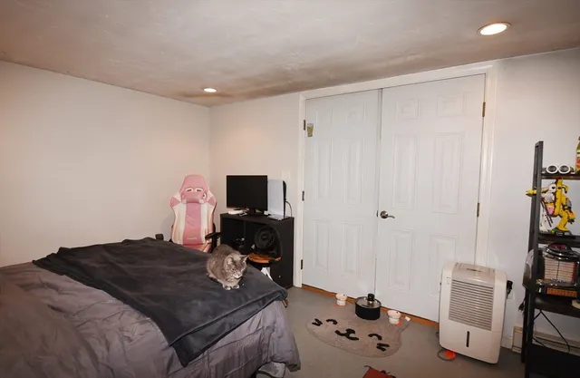 a bedroom with a bed and a computer on a desk