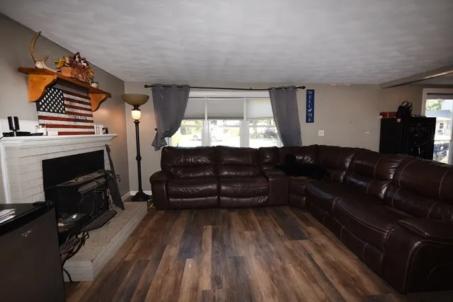 a living room with a couch wooden floor and a fireplace