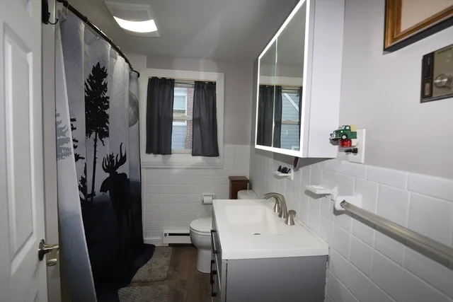a bathroom with a sink a toilet and shower
