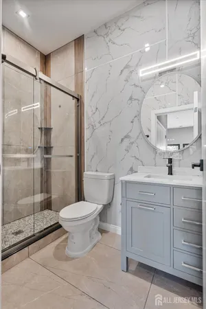 a bathroom with a granite countertop sink toilet and shower